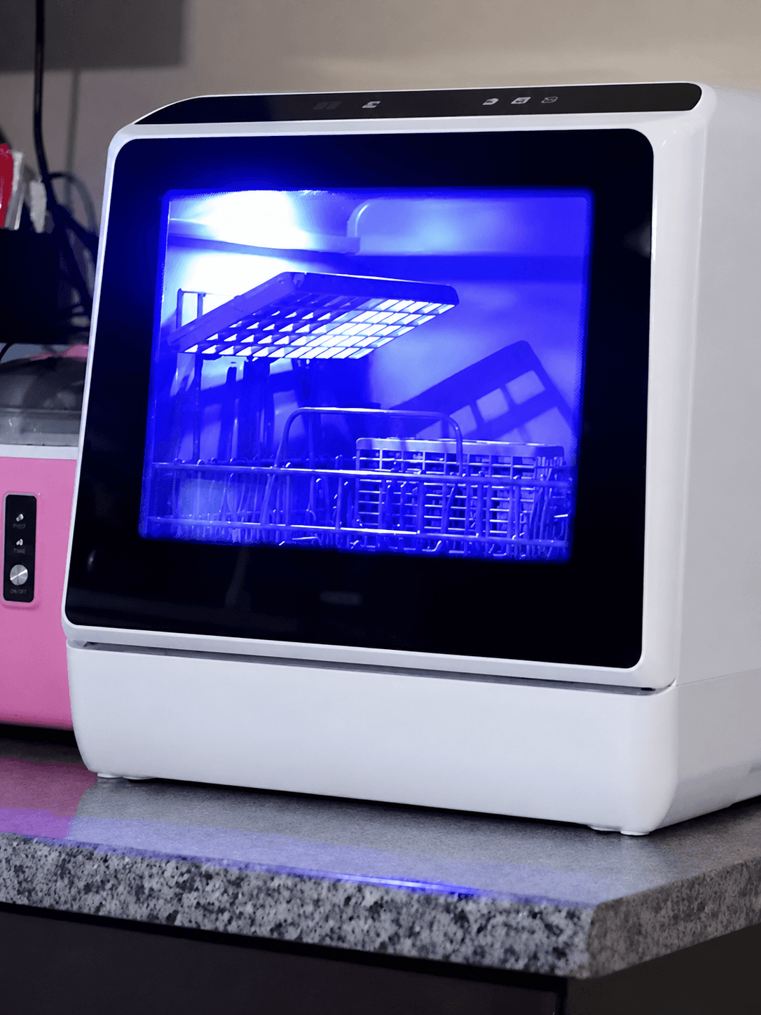 Countertop UV sanitizer with blue interior light and open racks inside.