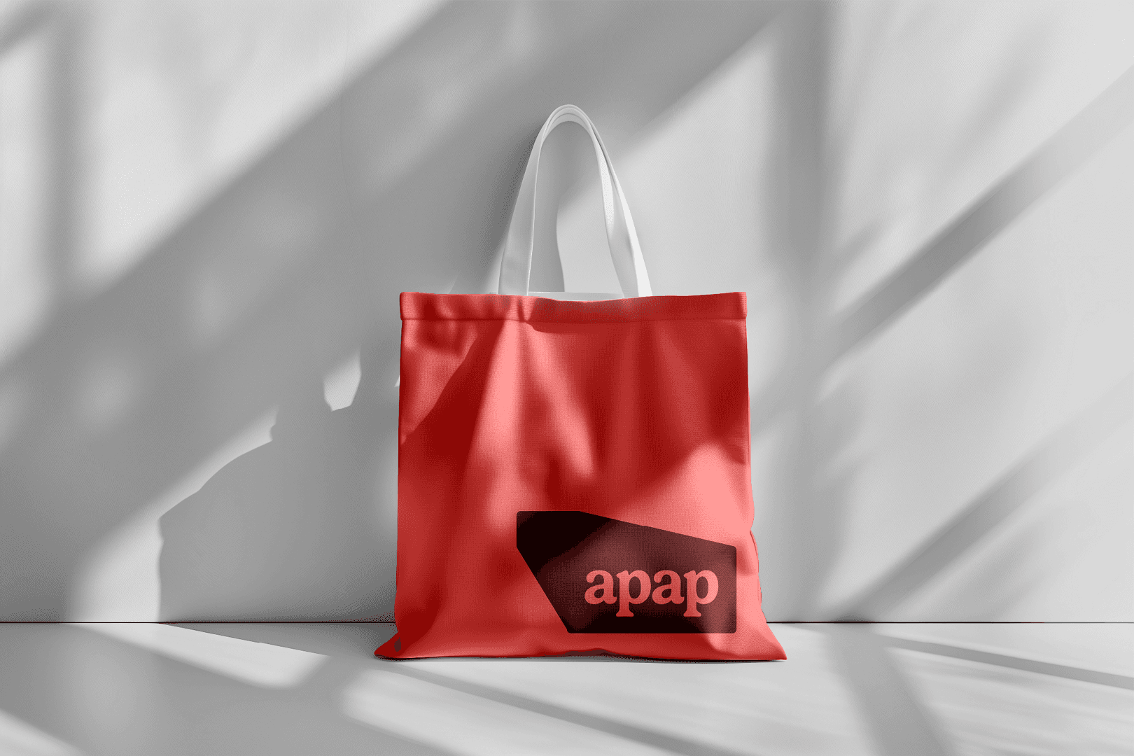 Red tote bag with APAP logo in the bottom right corner