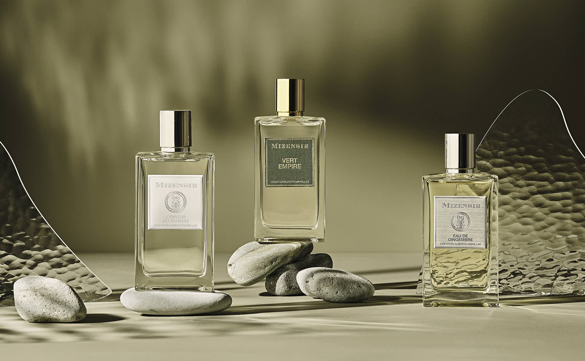 Three elegant perfume bottles are arranged on a surface, surrounded by soft, blurred background elements.