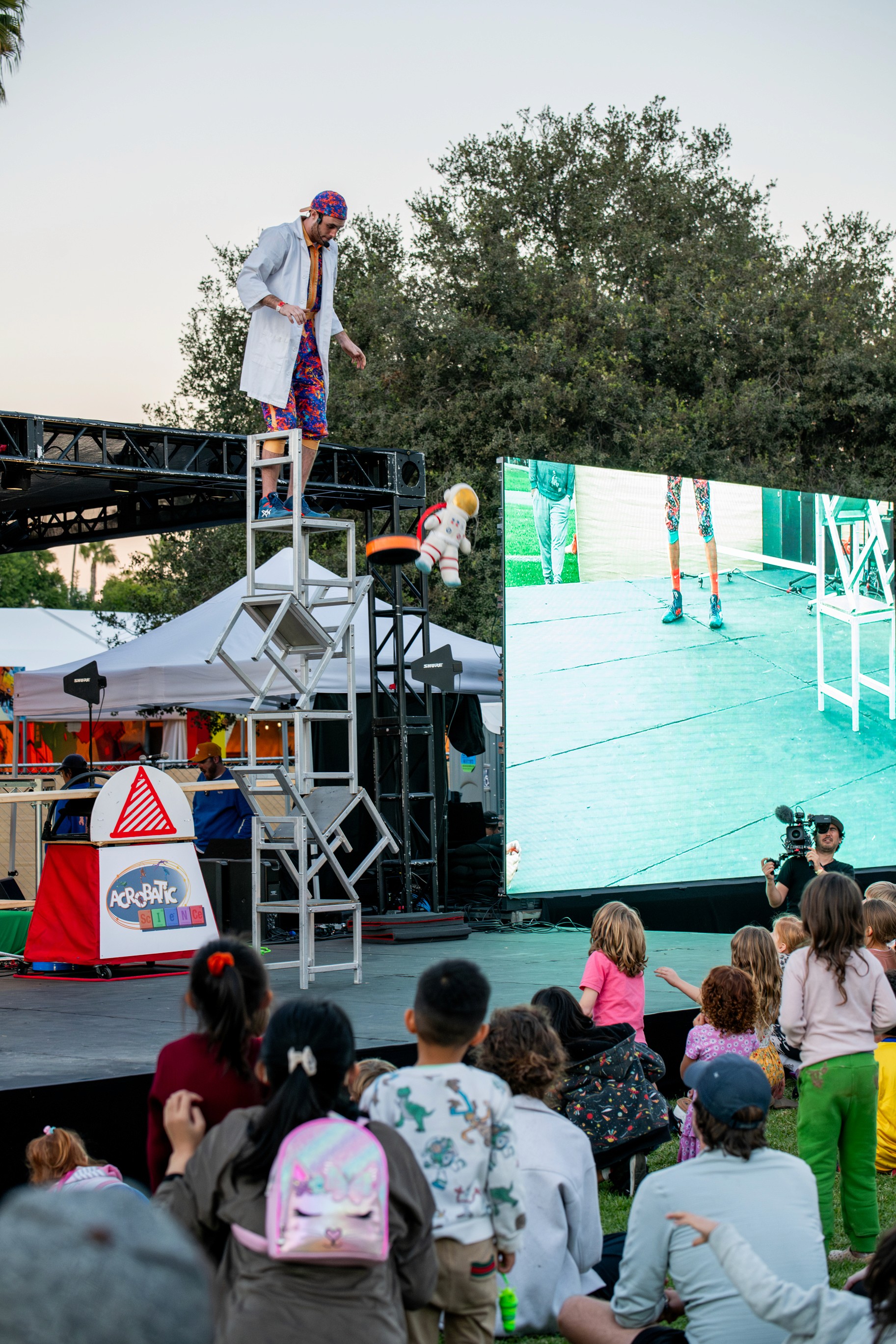 A close-up of a child's face lit up with excitement during a festival activity.
