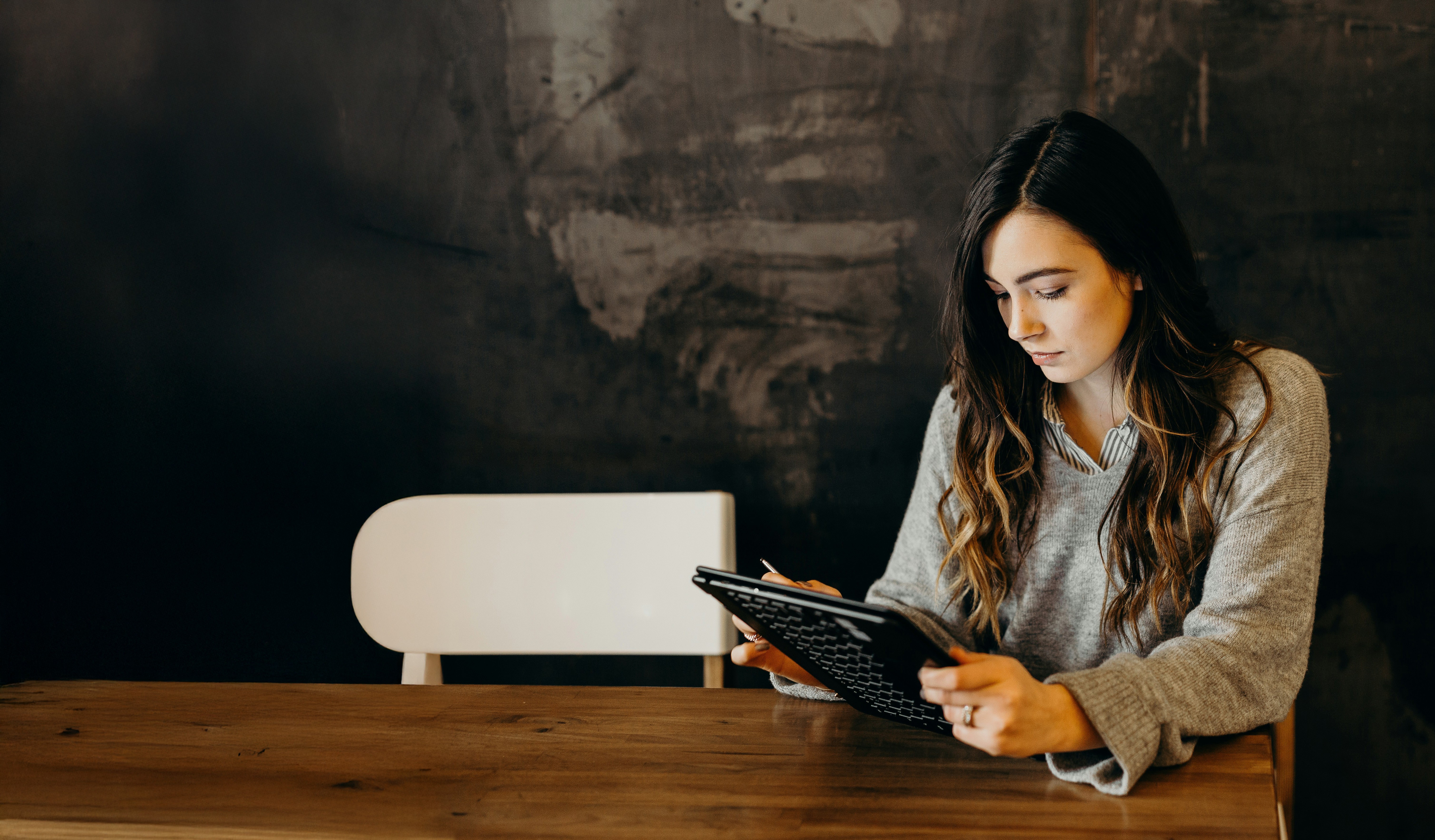 woman in blue tank top standing beside white wall