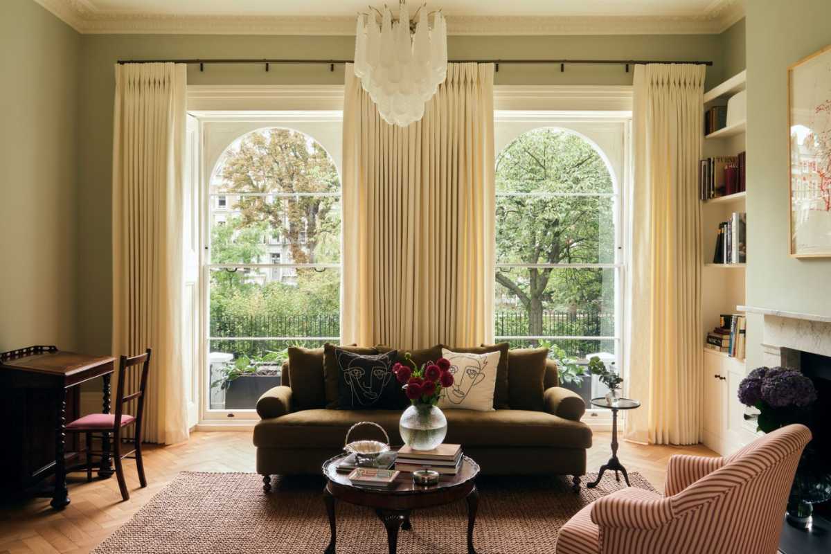 Elegant Kensington period townhouse drawing room crafted by top architects, showcasing grand arched sash windows, custom curtains, and plush seating