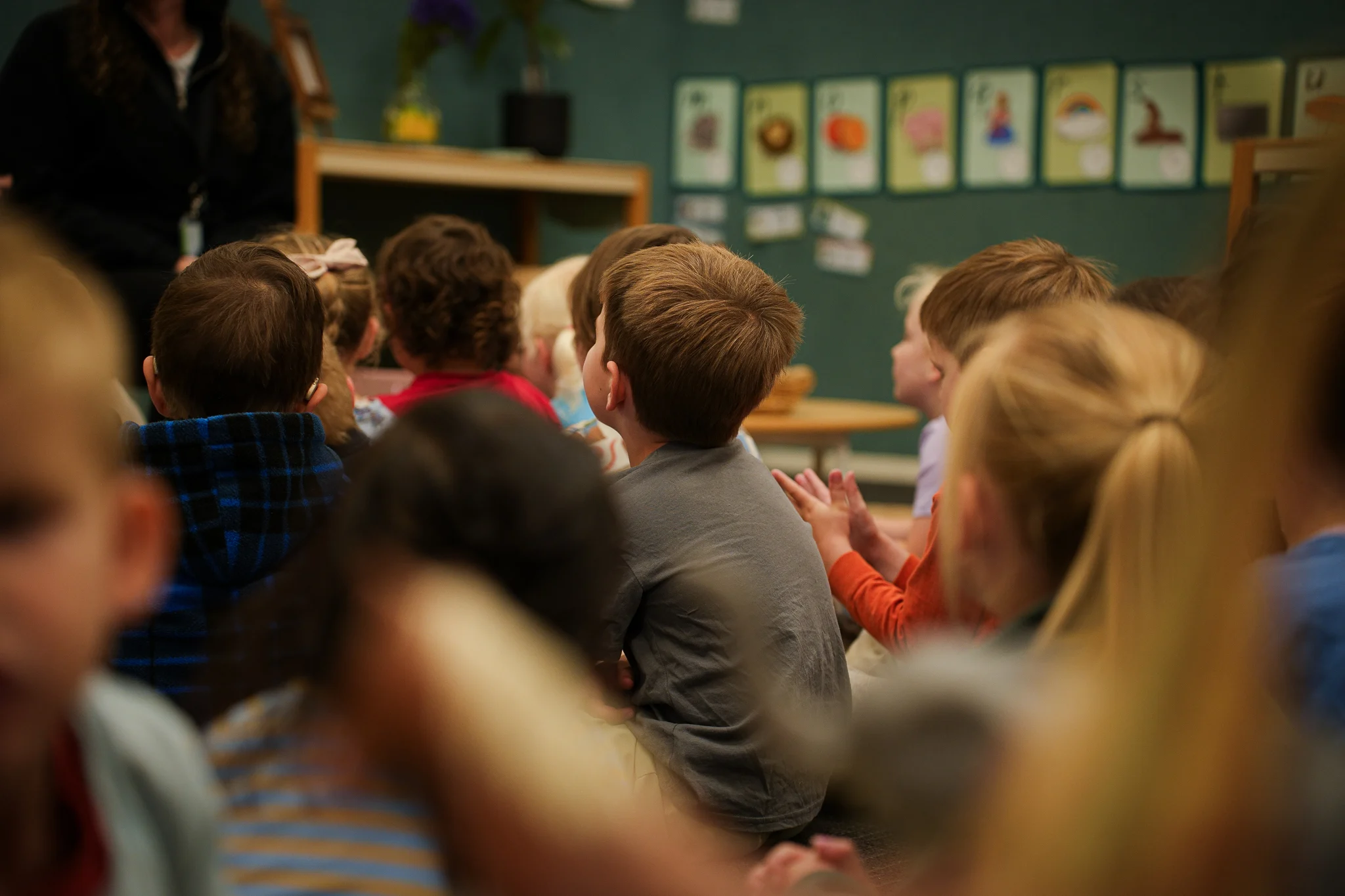 Young children engage in supervised water play with a teacher in an outdoor early childhood environment.