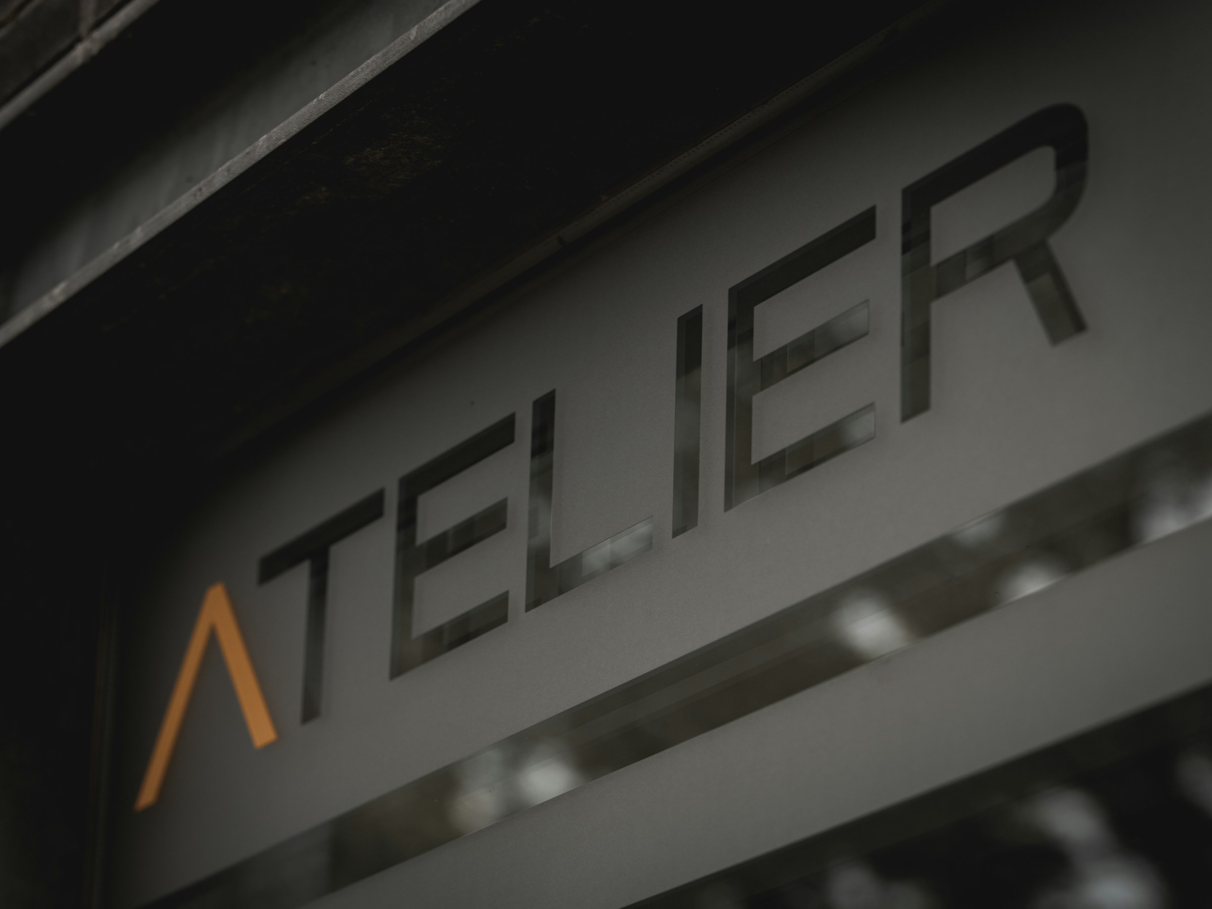 Minimal brand signage on a dark surface representing premium brand identity