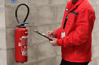 Agent de service de sécurité incendie SSIAP vérifiant les installations feu dans un bâtiment IGH.