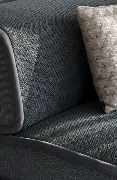 lateral view of an artistic soft armchair with waves and contrasting piping
