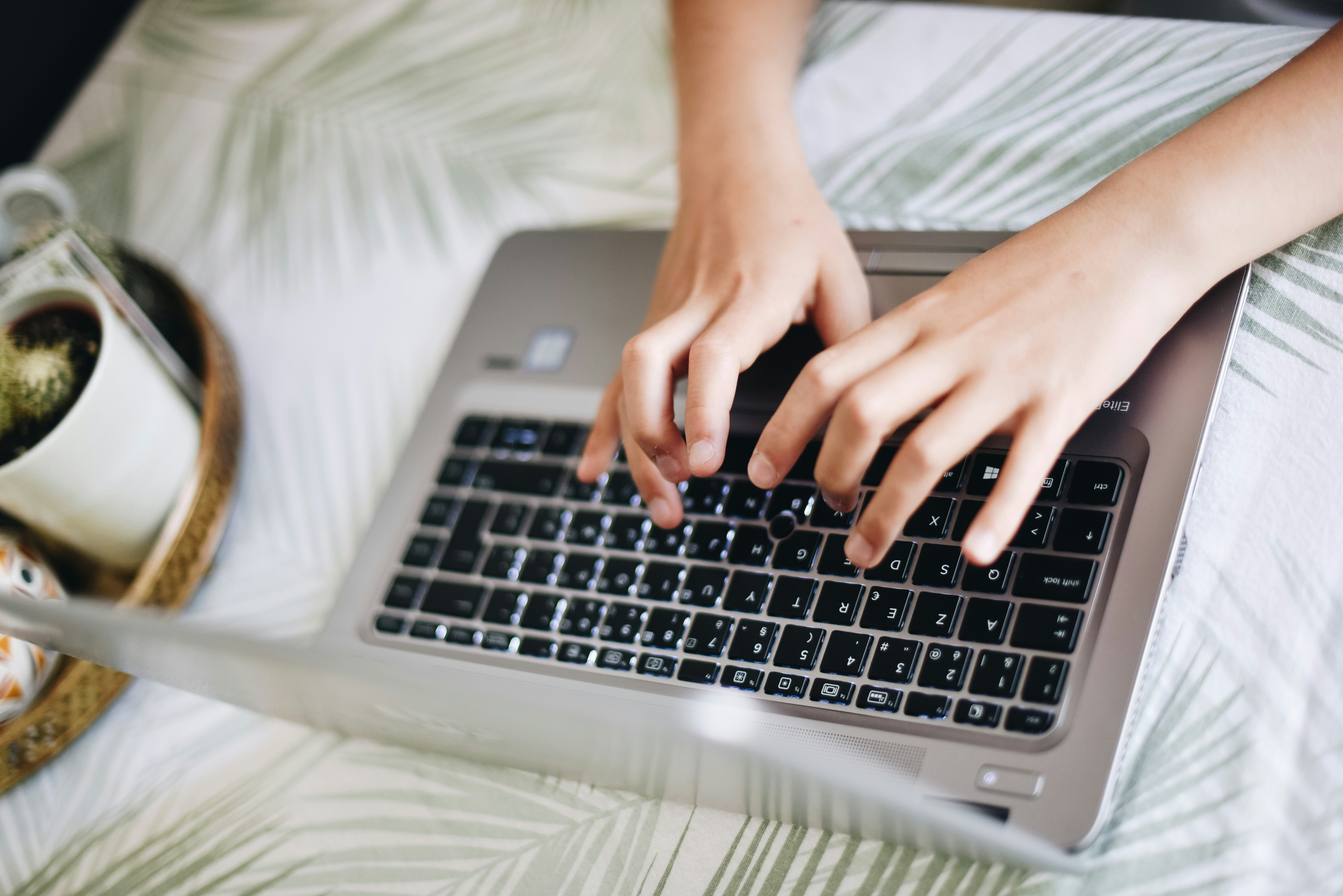 woman typing and outlining her research paper - Examples Of Research Topics