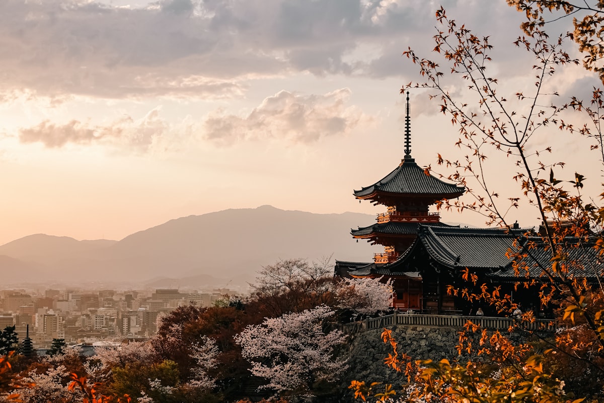 Traditional Kyoto temple framed by cherry blossoms at sunset, the best time to visit Japan for sakura