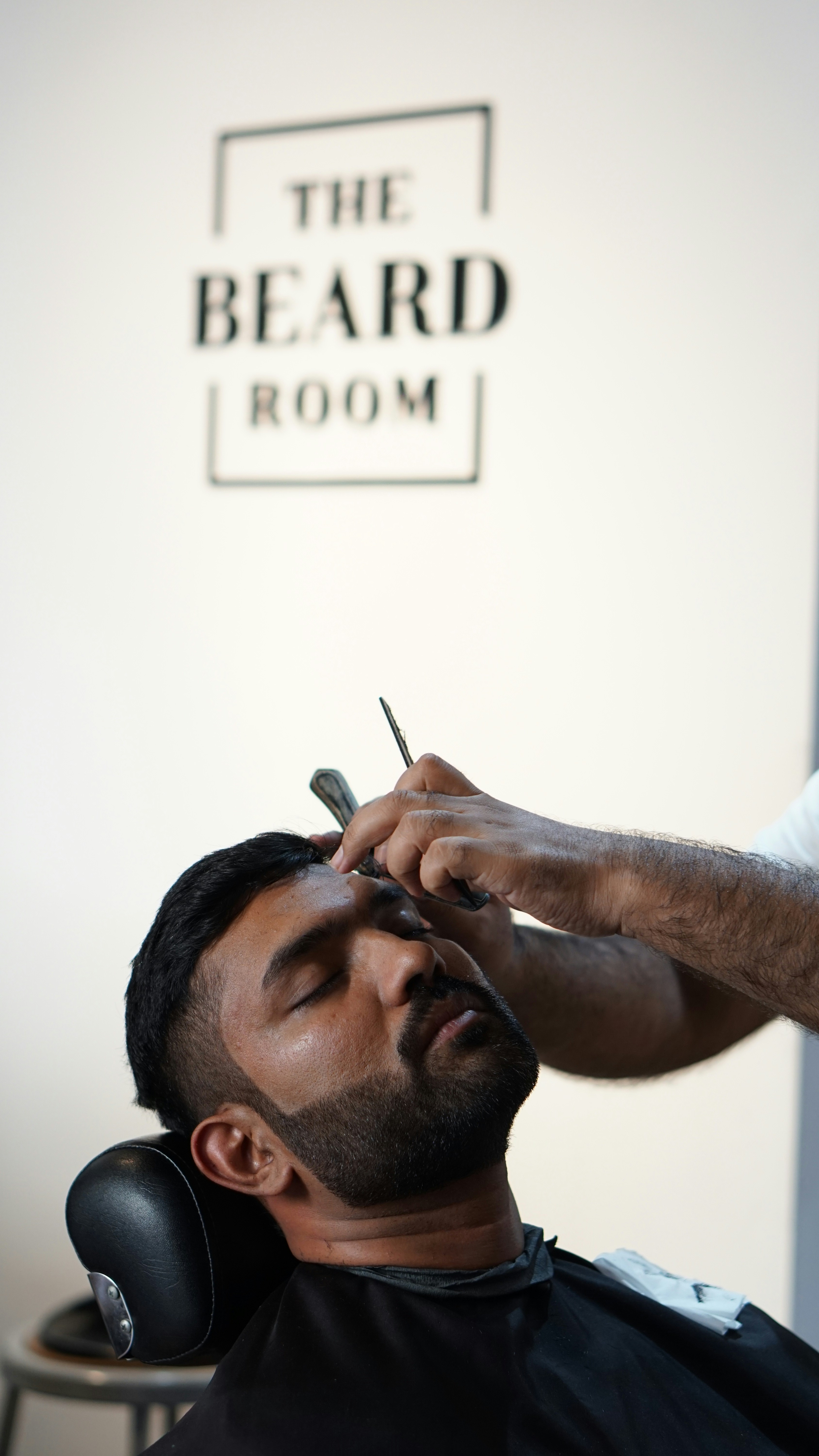 a man getting his hair cut by a barber