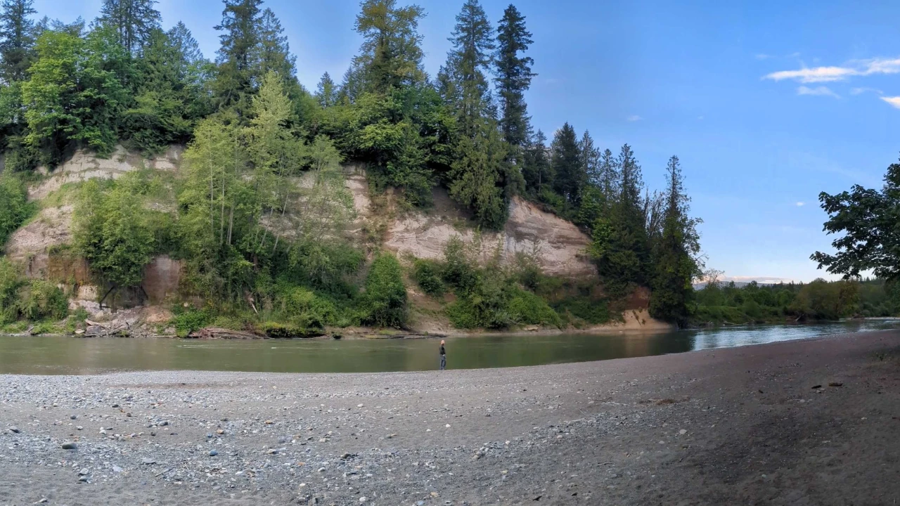 Scenic riverbank and forested cliffs along the trails at River Meadows County Park near Arlington, Washington.