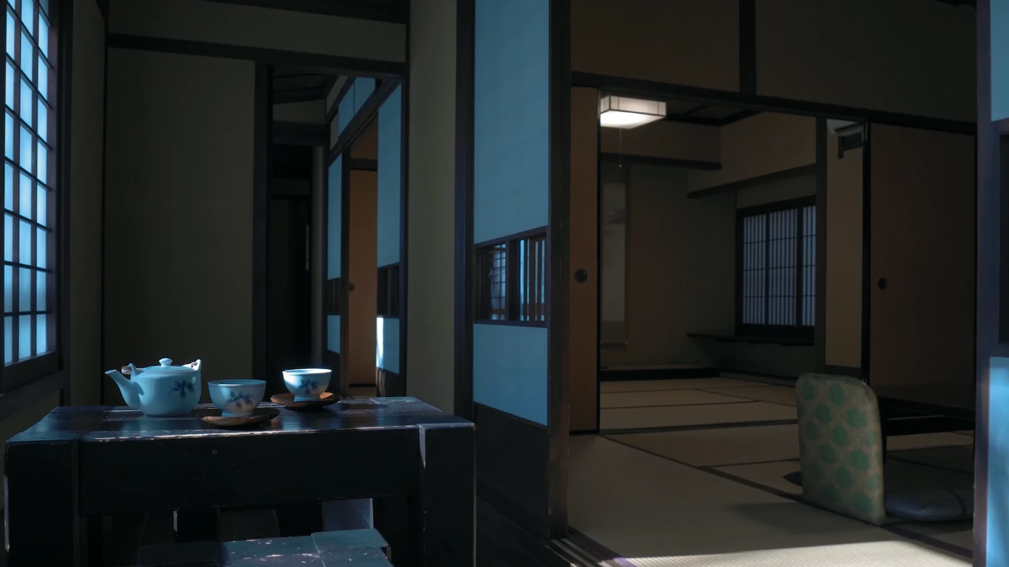 A tatami room at Kurokawa Onsen with a tea set on a low table and a corridor beyond