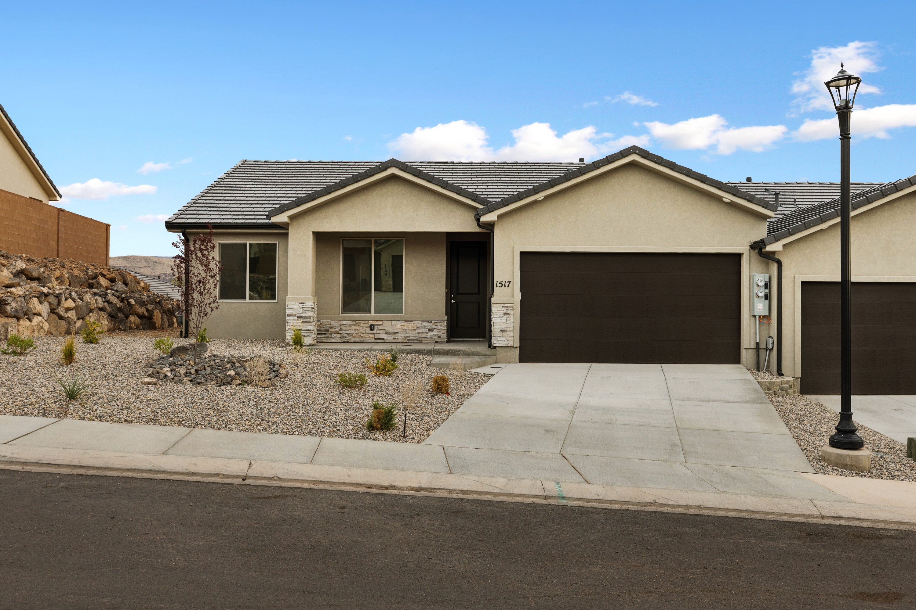 Street daytime view of The High Desert Home showing modern architecture and curb appeal in Hurricane Utah.