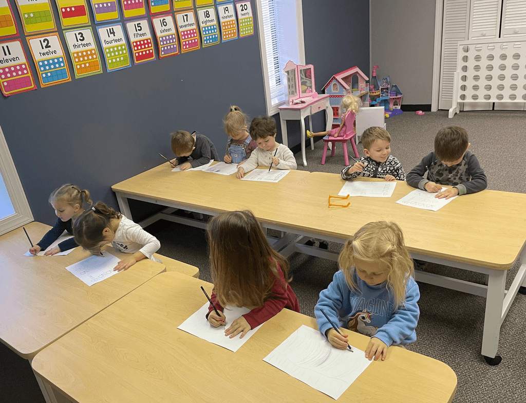 A group of kids at SportPlus Preschool in Charlotte doing a creative drawing exercise in one of our classrooms