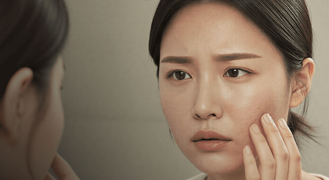 Woman examining her skin in a mirror