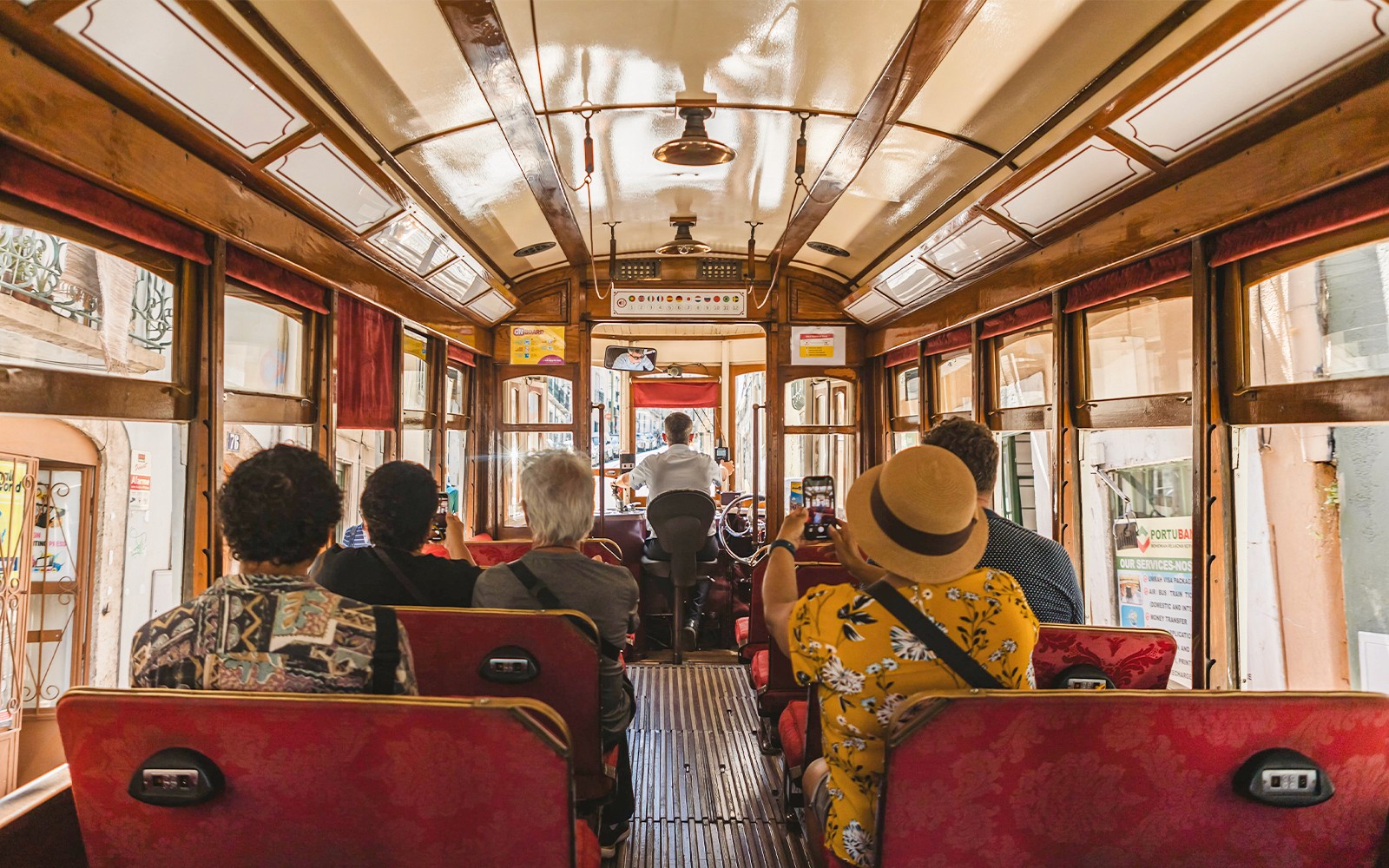 Touristen fotografieren in einer historischen Straßenbahn in Lissabon.