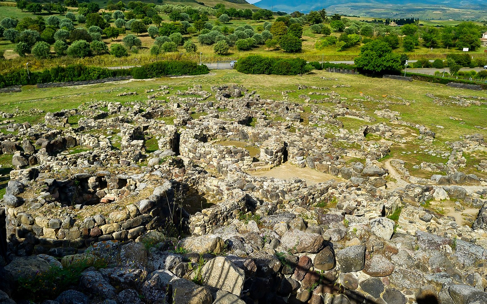 Ancient stone ruins at Barumini UNESCO site with green landscape in the background.
