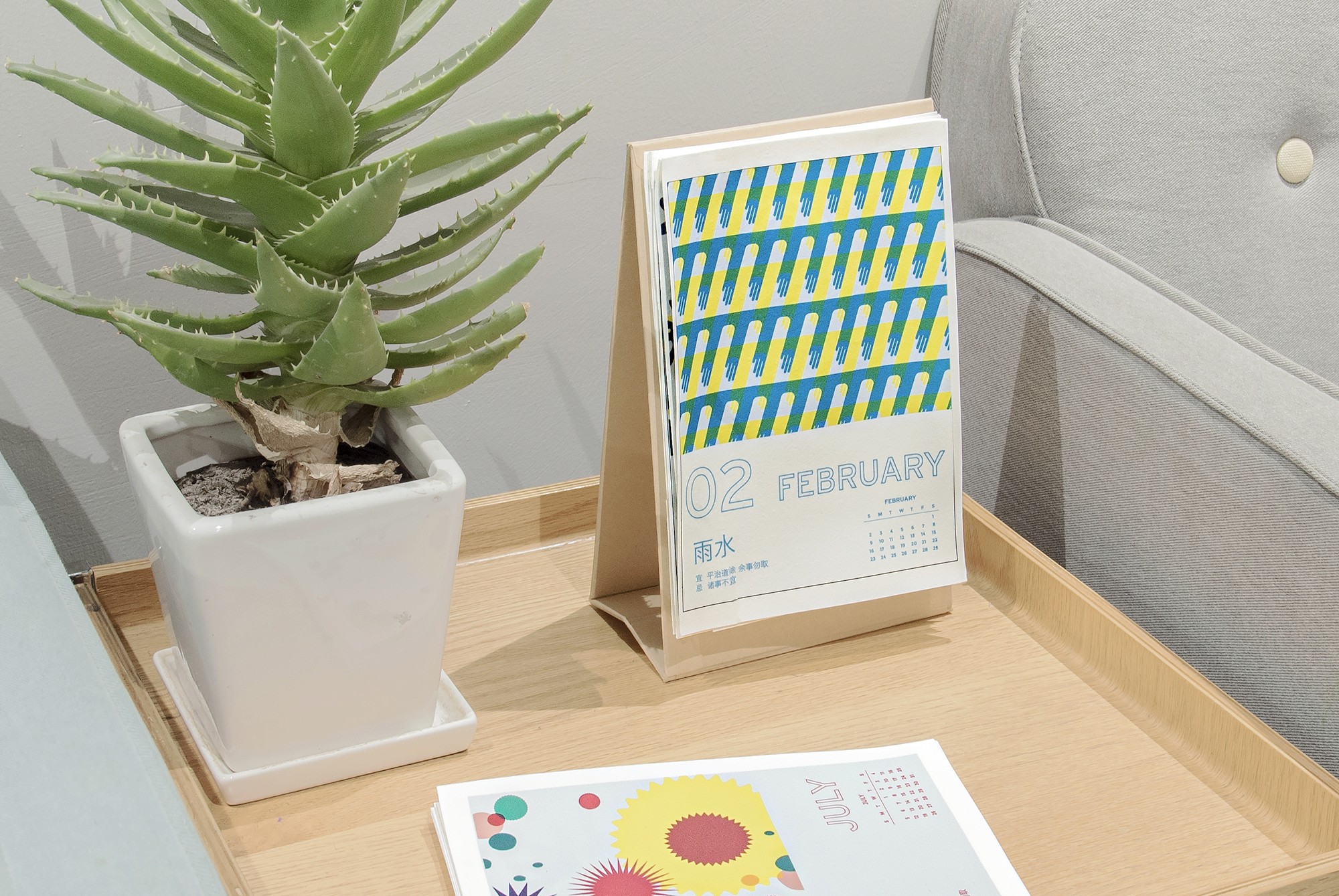 Miao Zhao calendar on a coffee table in a corner with cactus