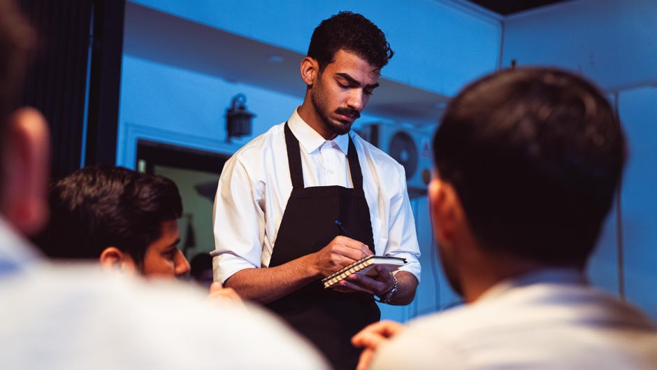 Chelner care ia comanda într-un restaurant, exemplu de activitate HoReCa unde se pot folosi zilieri plătiți doar pe ziua lucrată