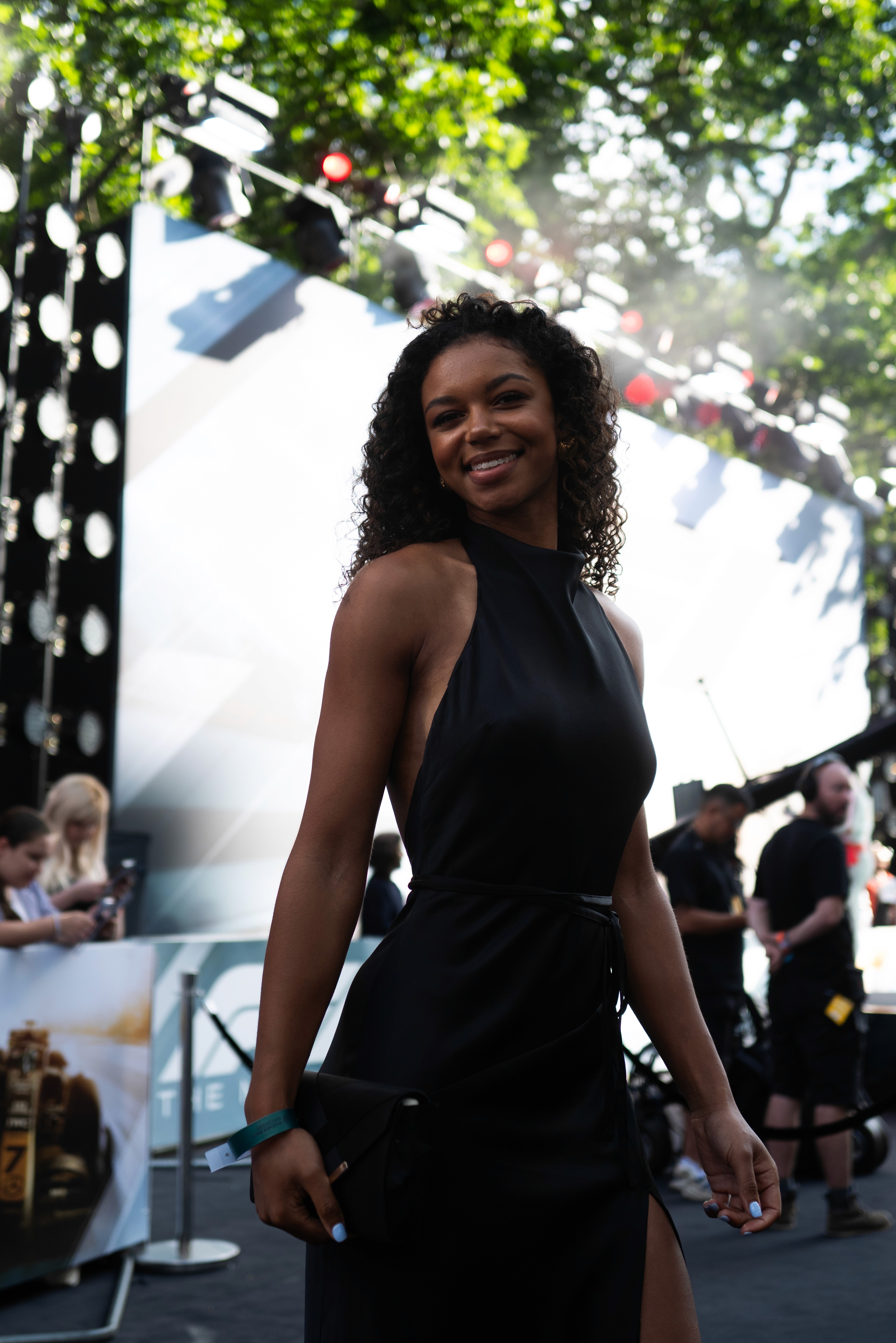 Bride sitting on ground against wall, groom standing nearby