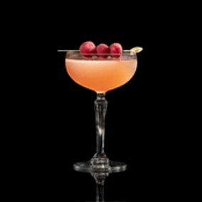 A closeup of a French Martini drink against a dark background.