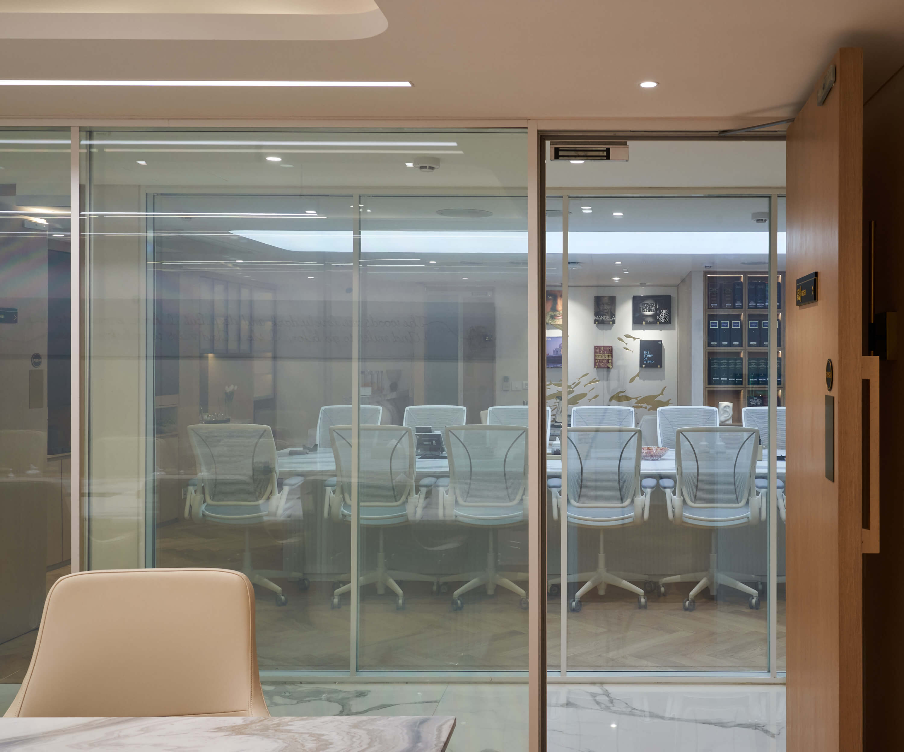 Glass-lined office corridor with marble flooring and meeting room views.