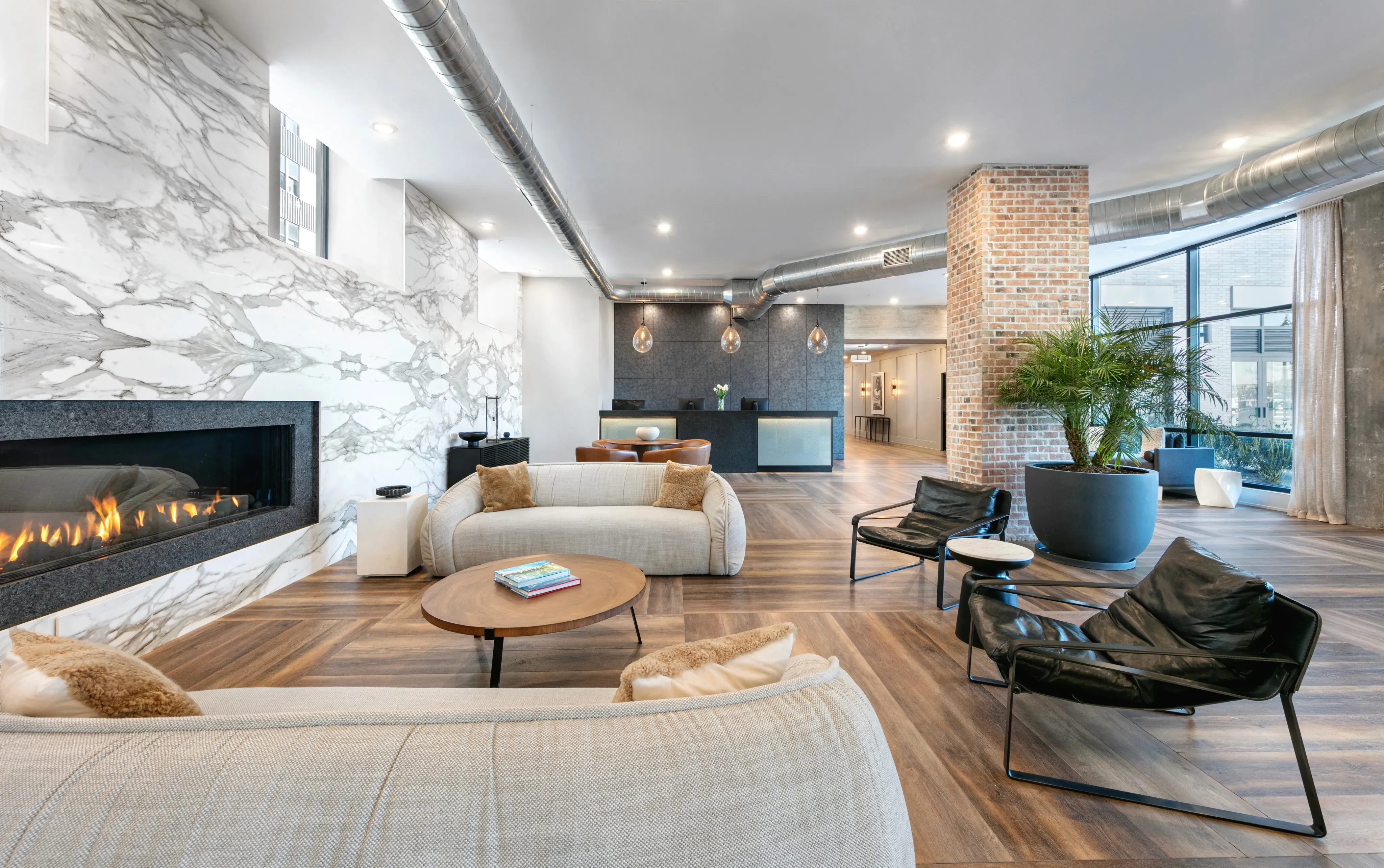 Modern living room with a fireplace, stylish furniture, and large windows allowing natural light.