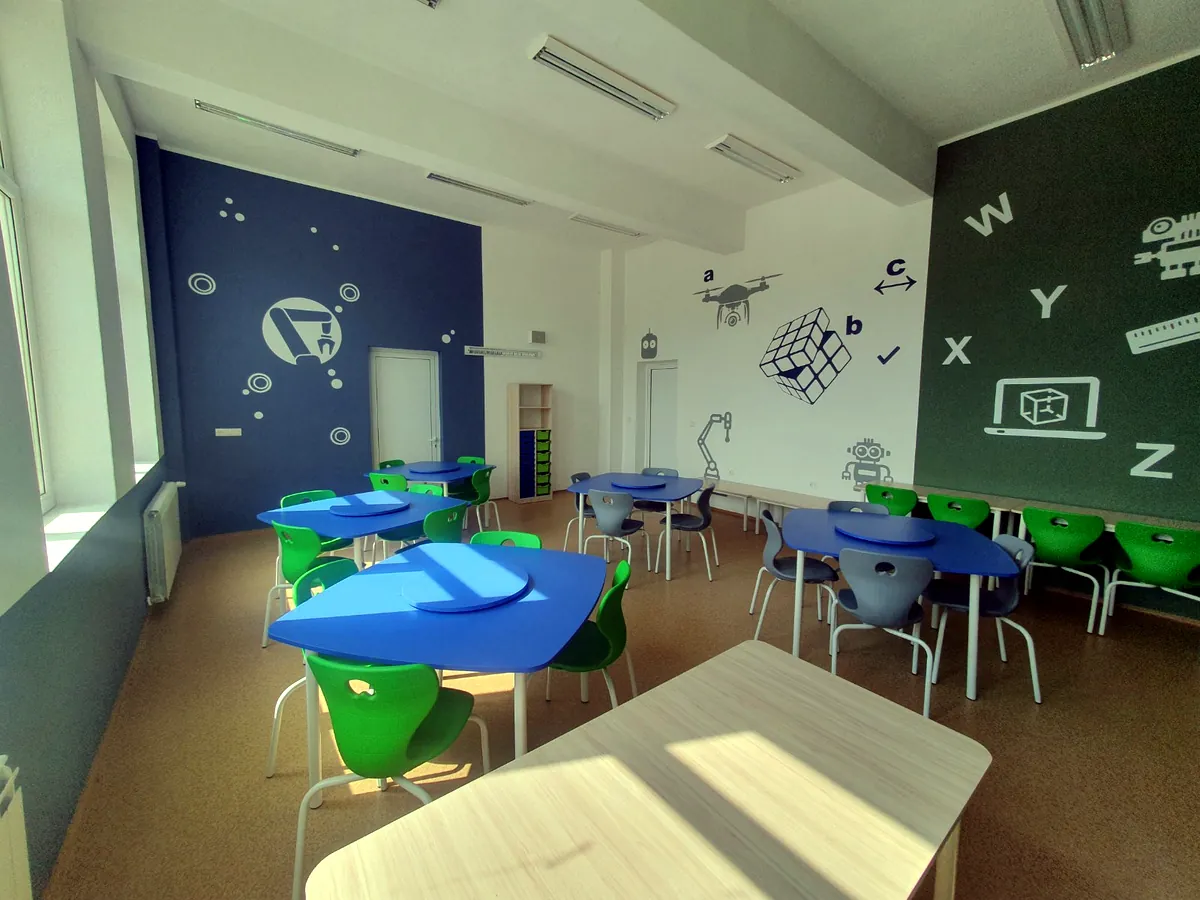 Green and blue stackable school chairs in a science learning room