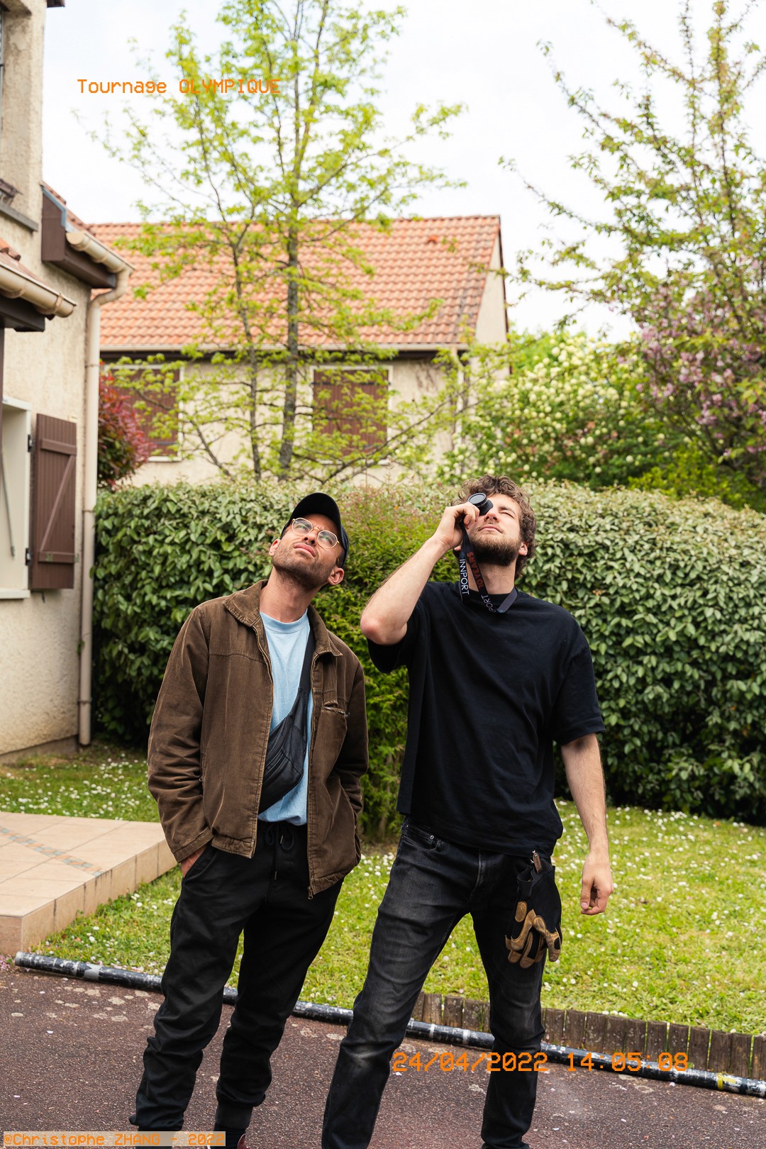 Deux membres de l’équipe observent le ciel avec un viewfinder devant une maison.
