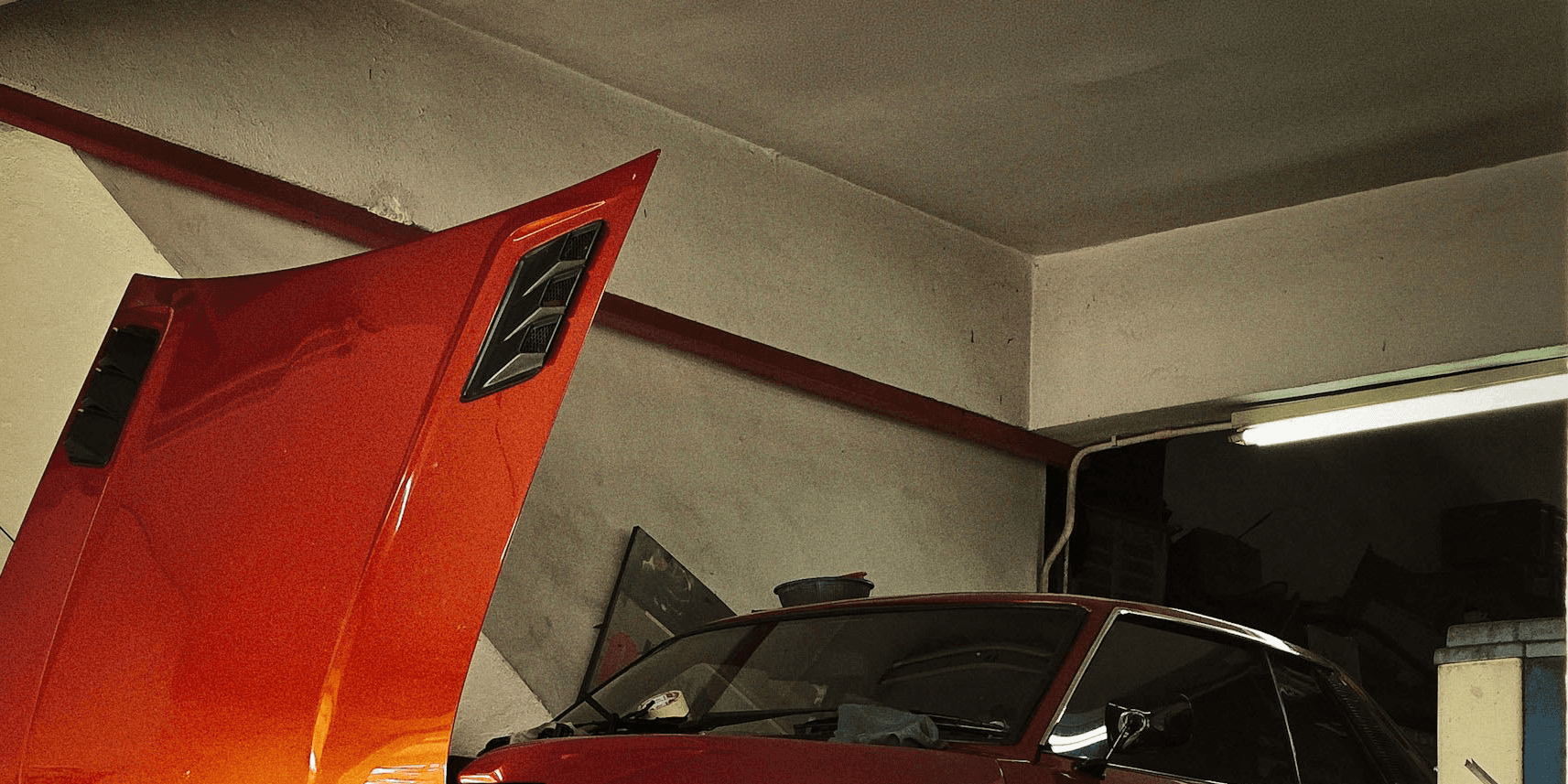 Orange classic car being repaired in garage