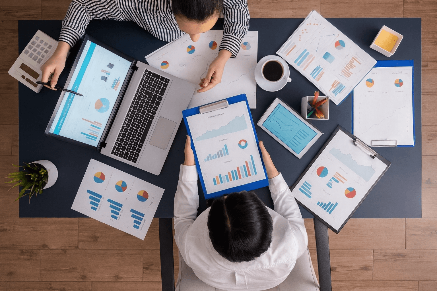 Des professionnels analysant des graphiques et des données sur un bureau rempli de documents et d'ordinateurs, symbolisant l'expertise d'une agence spécialisée pour optimiser les ventes sur Amazon.ajustements qui s'imposent
