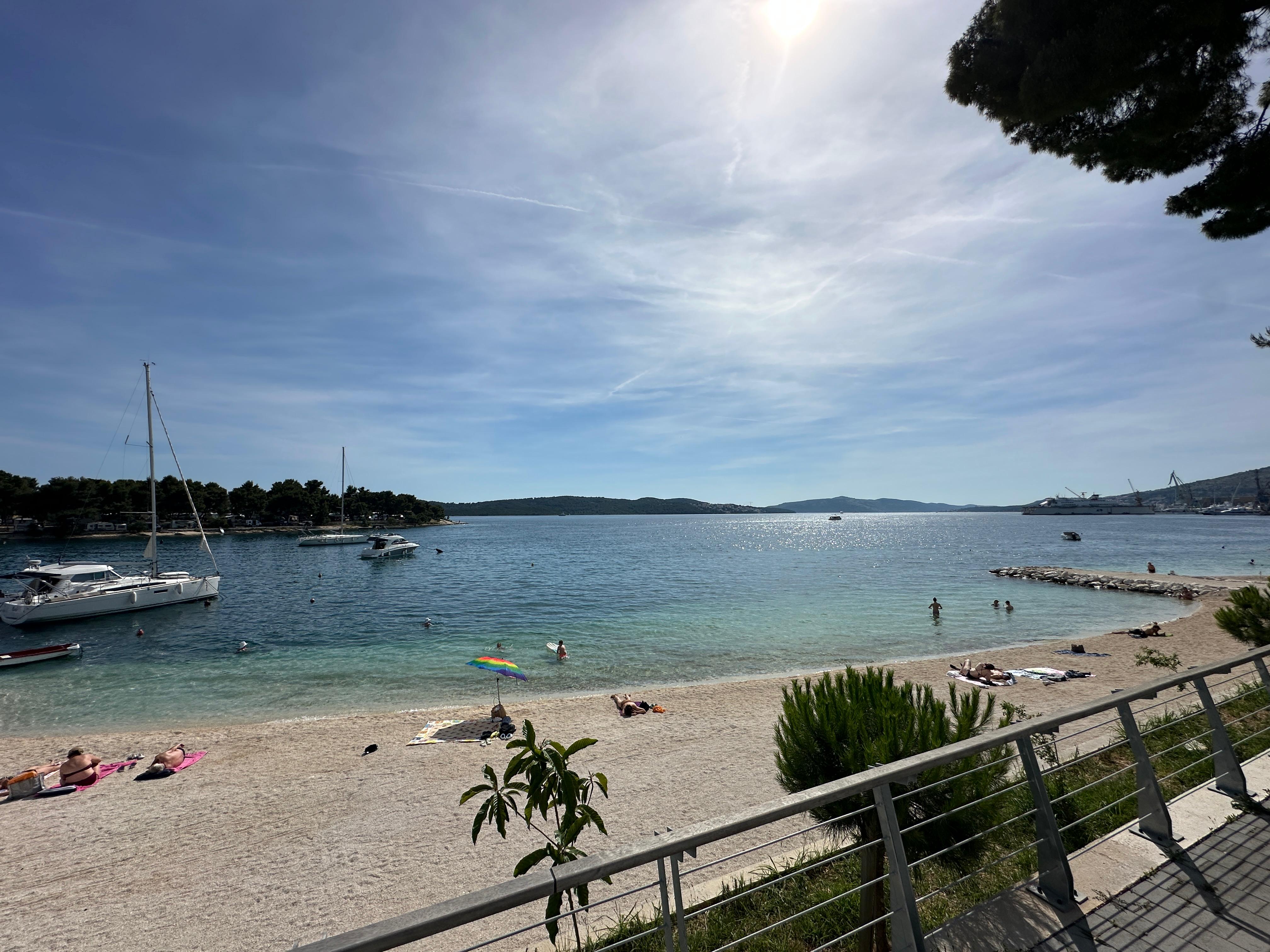 Black sports car in front of a modern, futuristic curved building.