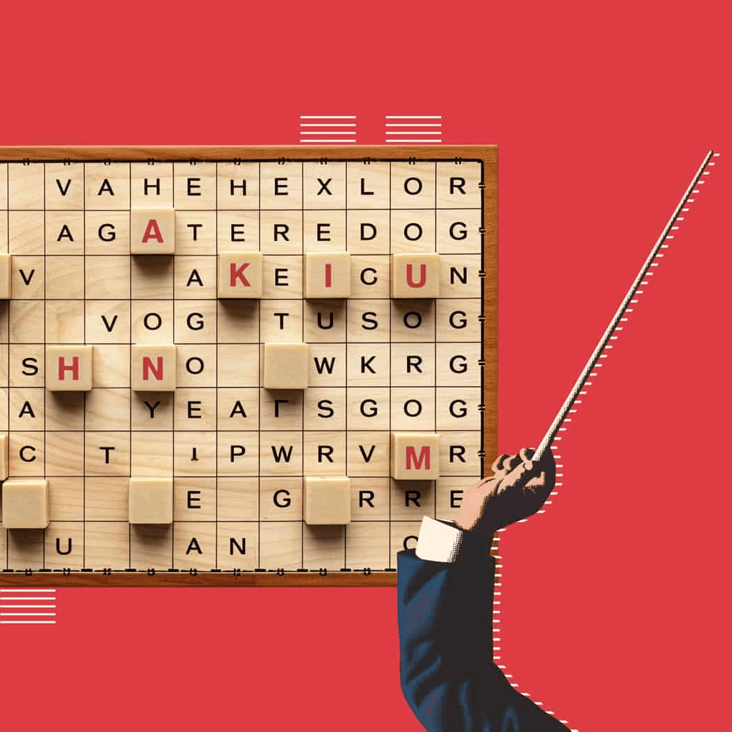 Crucigrama de palabras en tablero de madera con fondo rojo y mano señalando con vara.