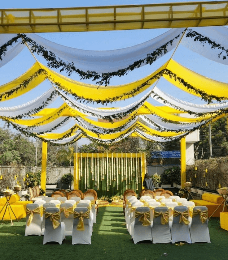 Outdoor Haldi decoration with yellow drapes & real marigold on green lawn, perfect farmhouse & resort garden decor in Gurgaon