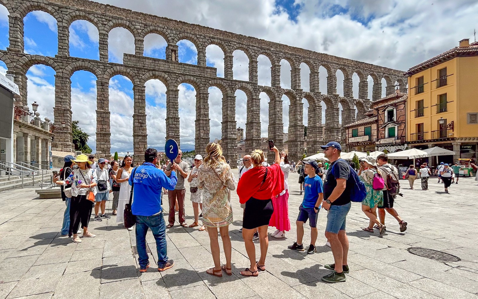游客与导游在西班牙塞戈维亚的罗马高架渠观光。