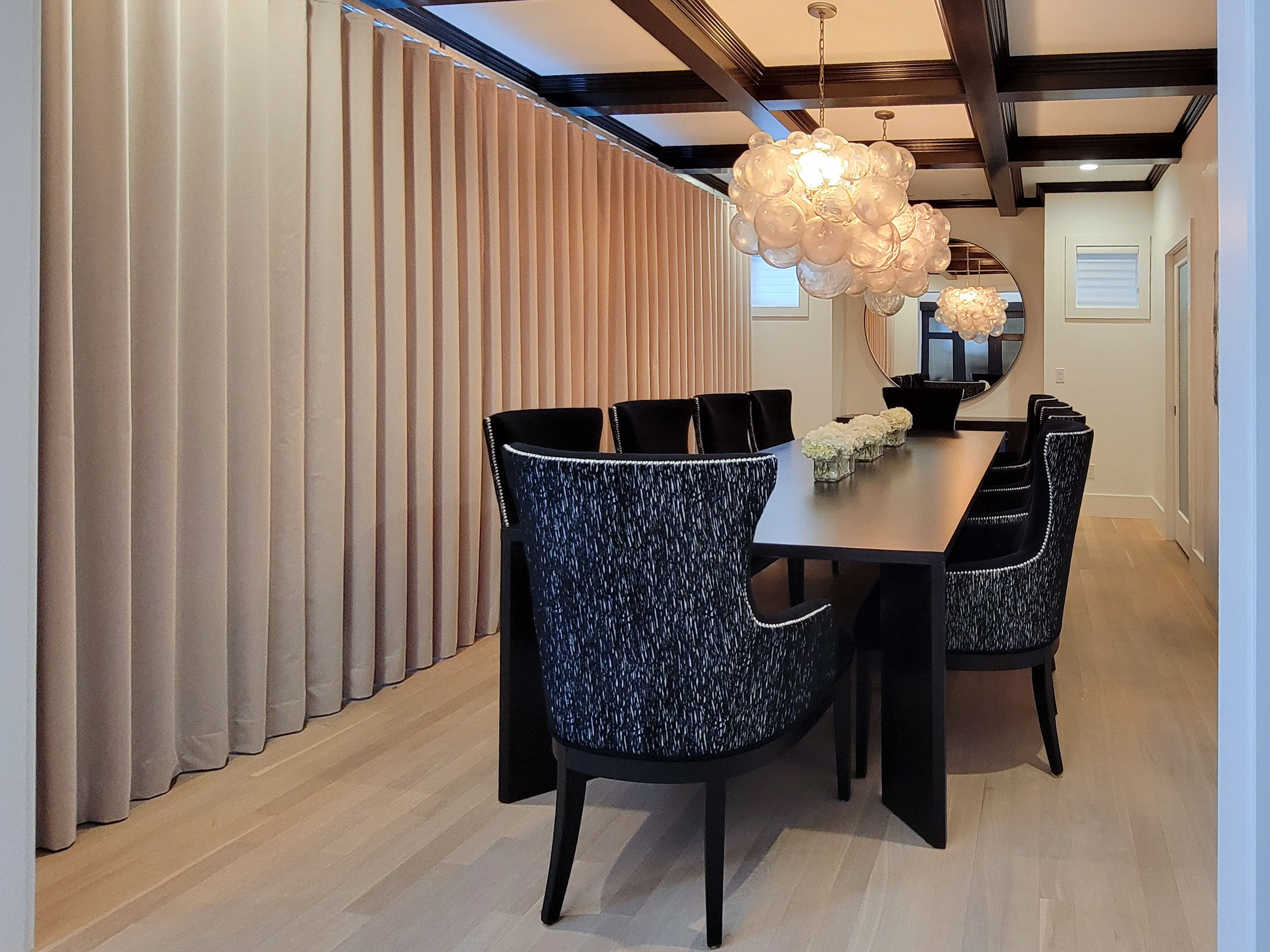 Image of Luxury dining room design with dark table, chairs, and modern light fixtures by KHD Homes.