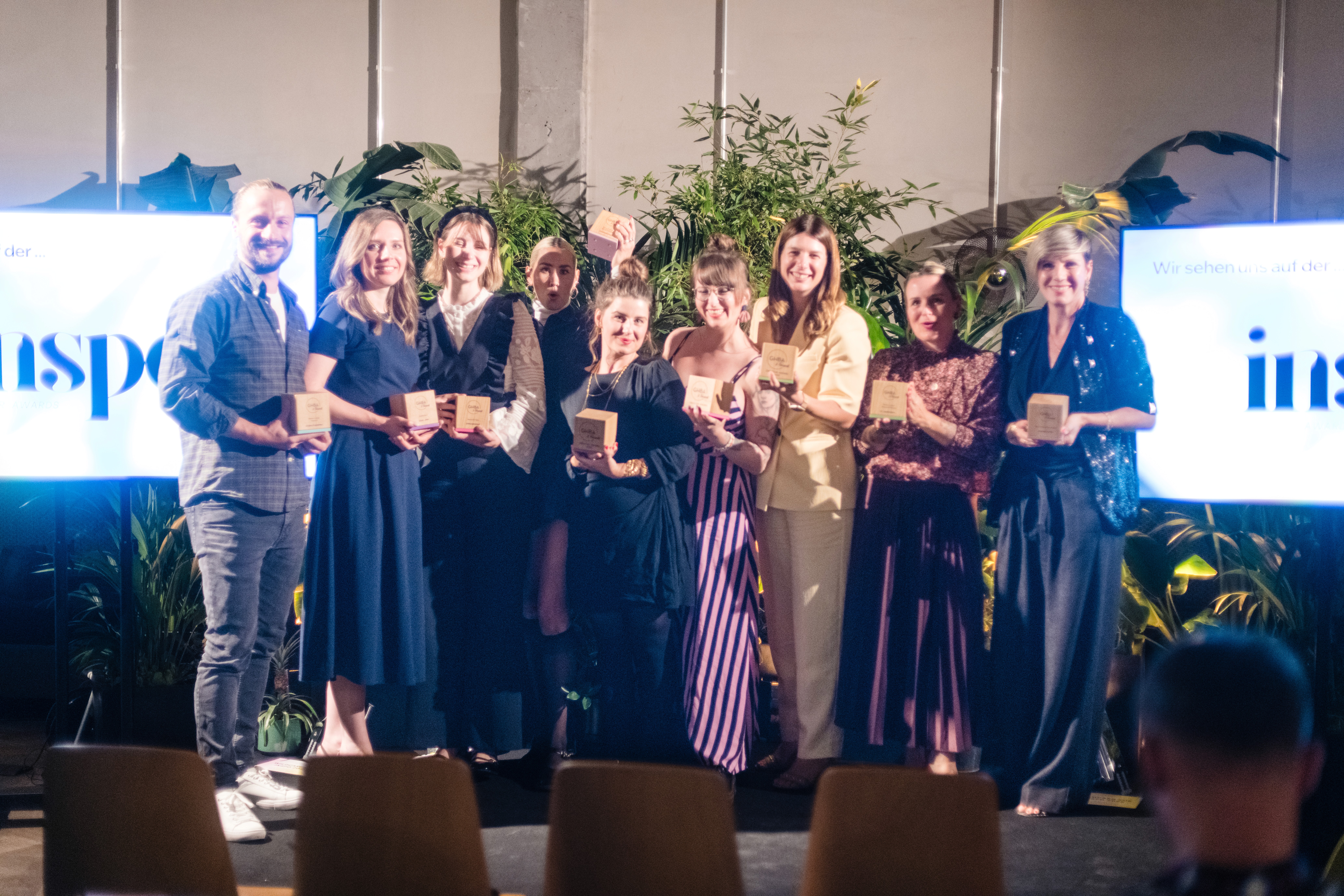 Preisträgerinnen stehen bei einer Awardverleihung gemeinsam auf der Bühne und halten ihre Auszeichnungen.