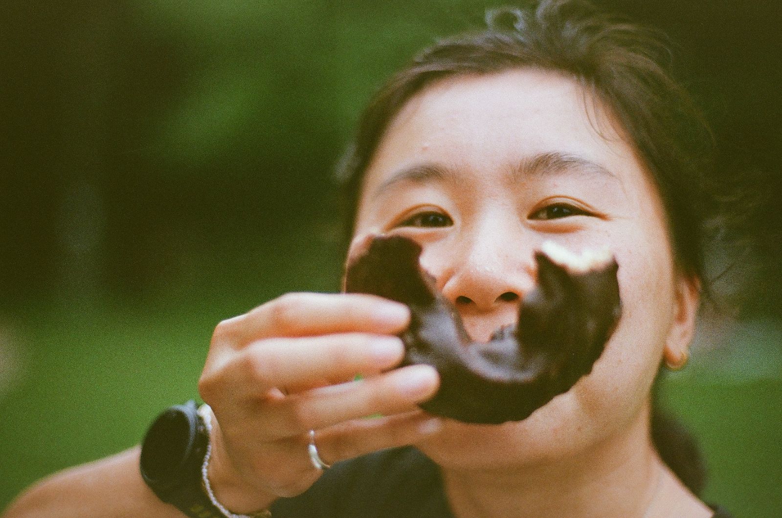 A thoughtful young person with dark hair gazes to the side, captured in soft black and white lighting.
