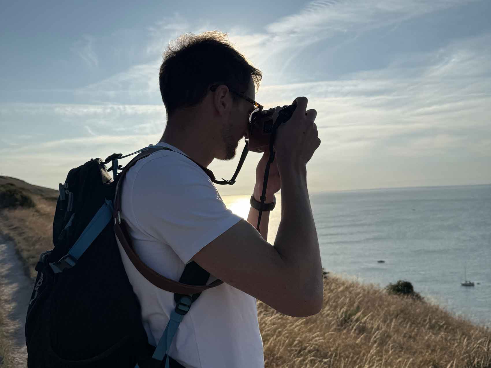 A film photographer taking a photo of the ocean