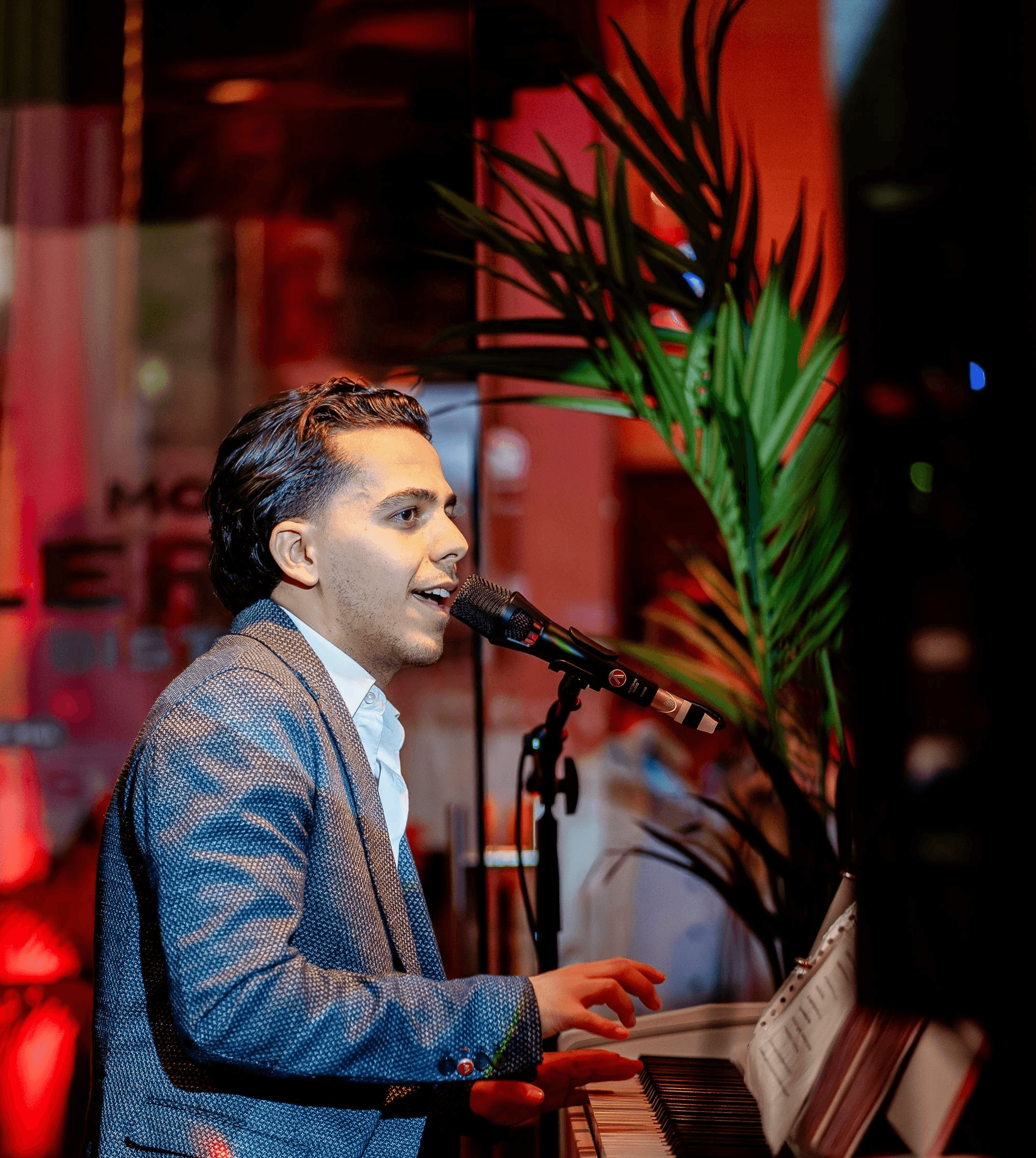 Three people in trench coats walk past a neon storefront.