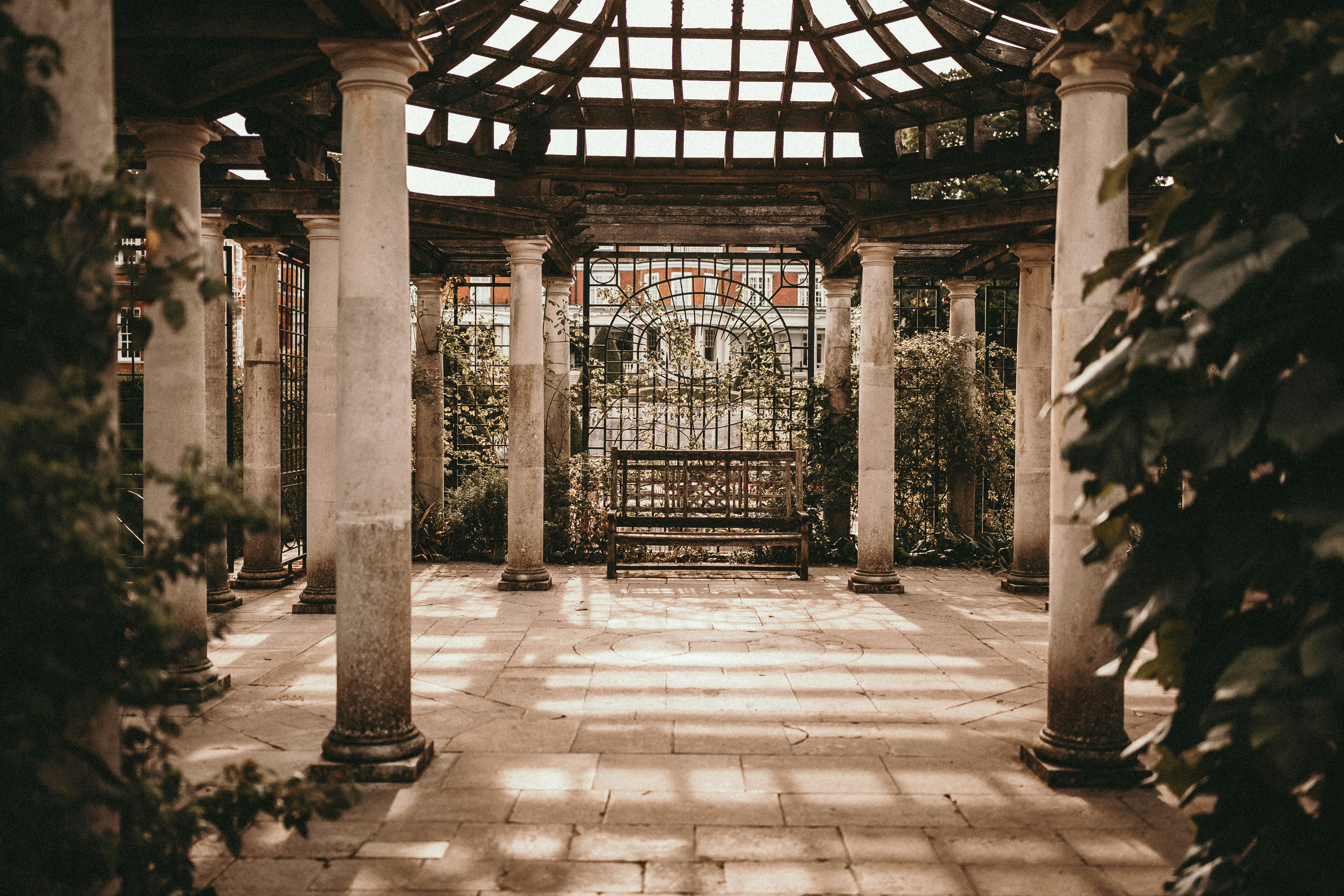 empty wooden bench between stone pillars