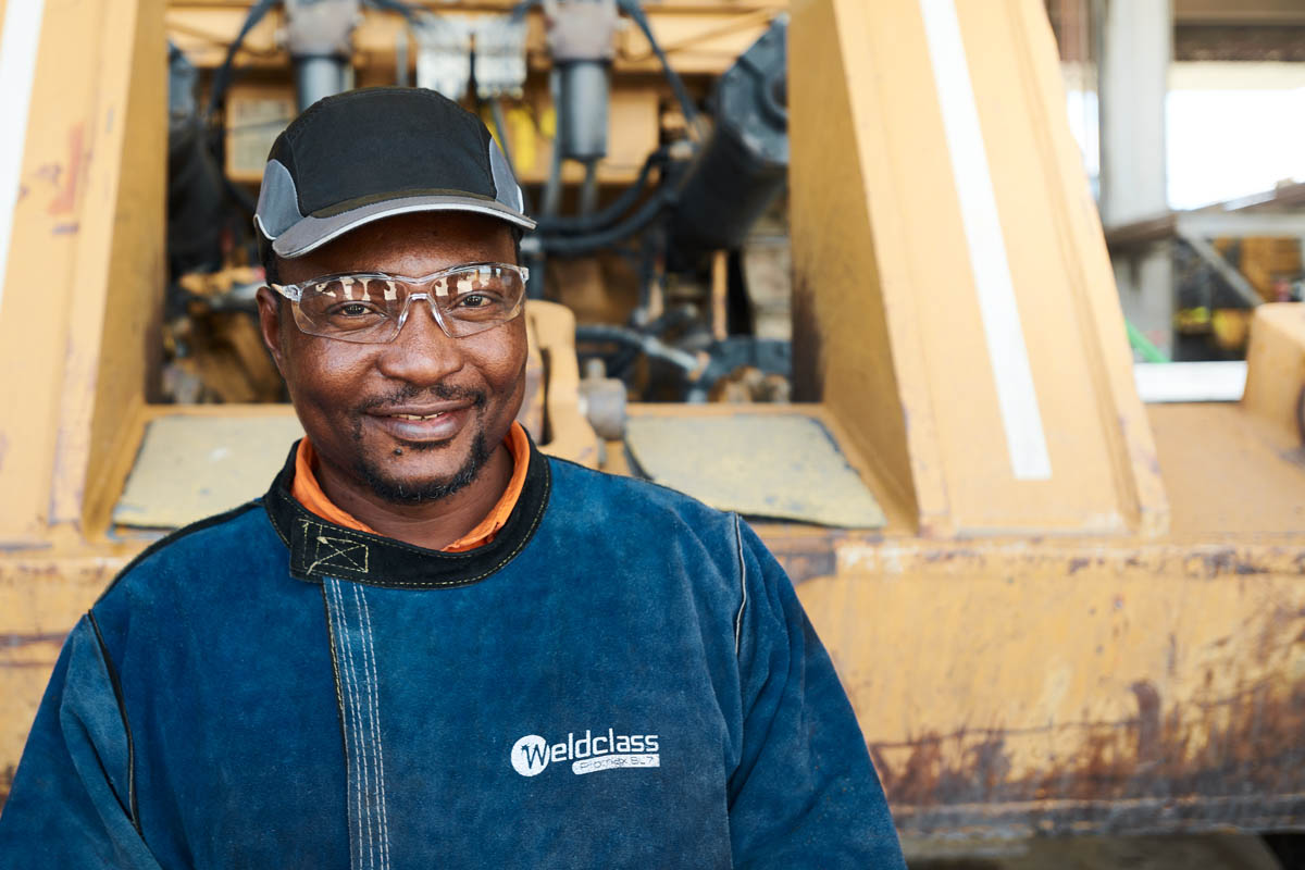 Worker in cap and safety glasses at industrial site - Weldclass branding