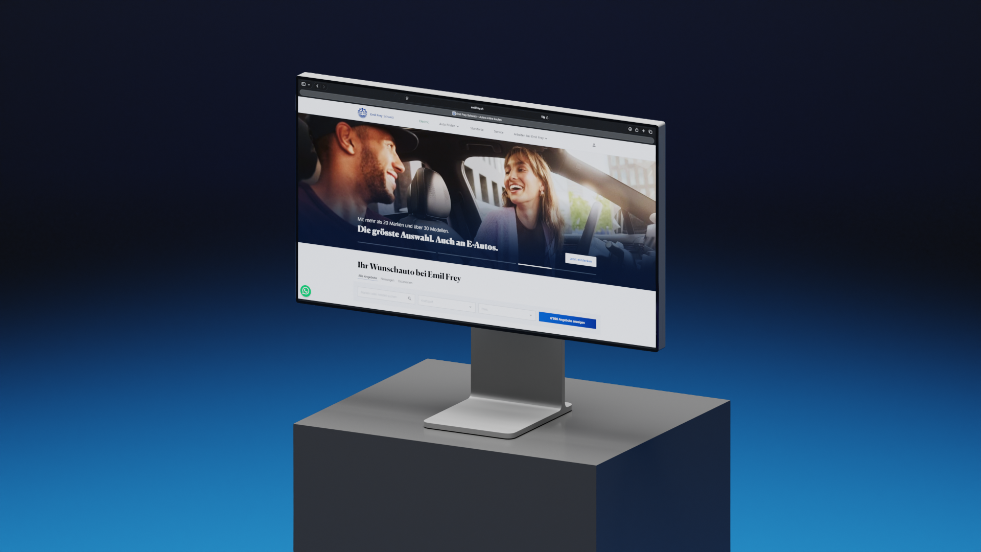 Ein Desktop-Monitor auf einem Ständer, auf dem die Website von Emil Frey angezeigt wird.
