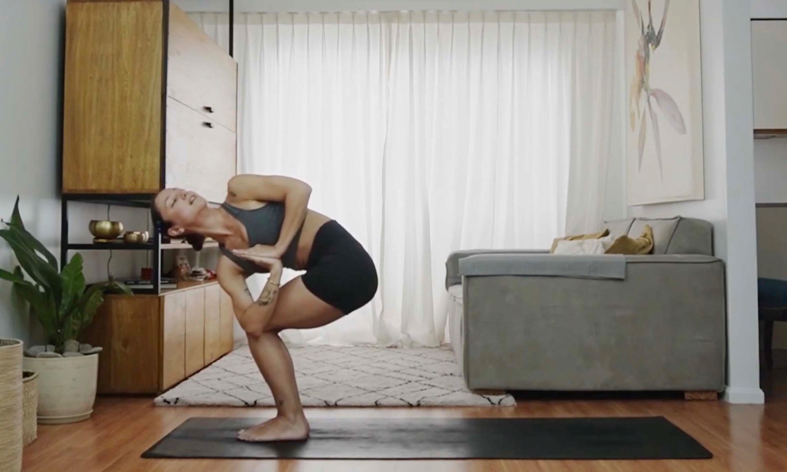 Flavia Siutti realizando una postura de equilibrio en cuclillas durante una práctica de yoga.