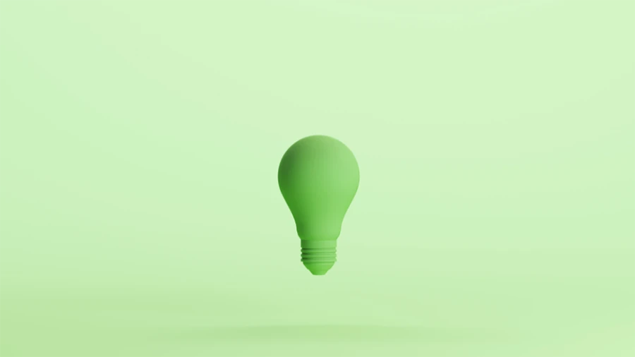 Green lightbulb on green background.