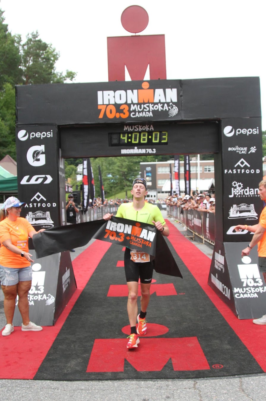Triathlete crossing the finish line at Ironman 70.3 Muskoka