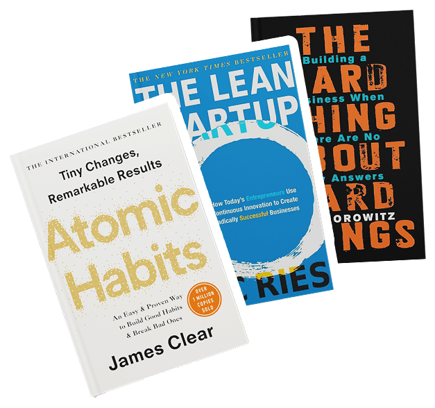 Three business books standing upright against a checkered background: "Atomic Habits," "The Lean Startup," and "The Hard Thing About Hard Things."