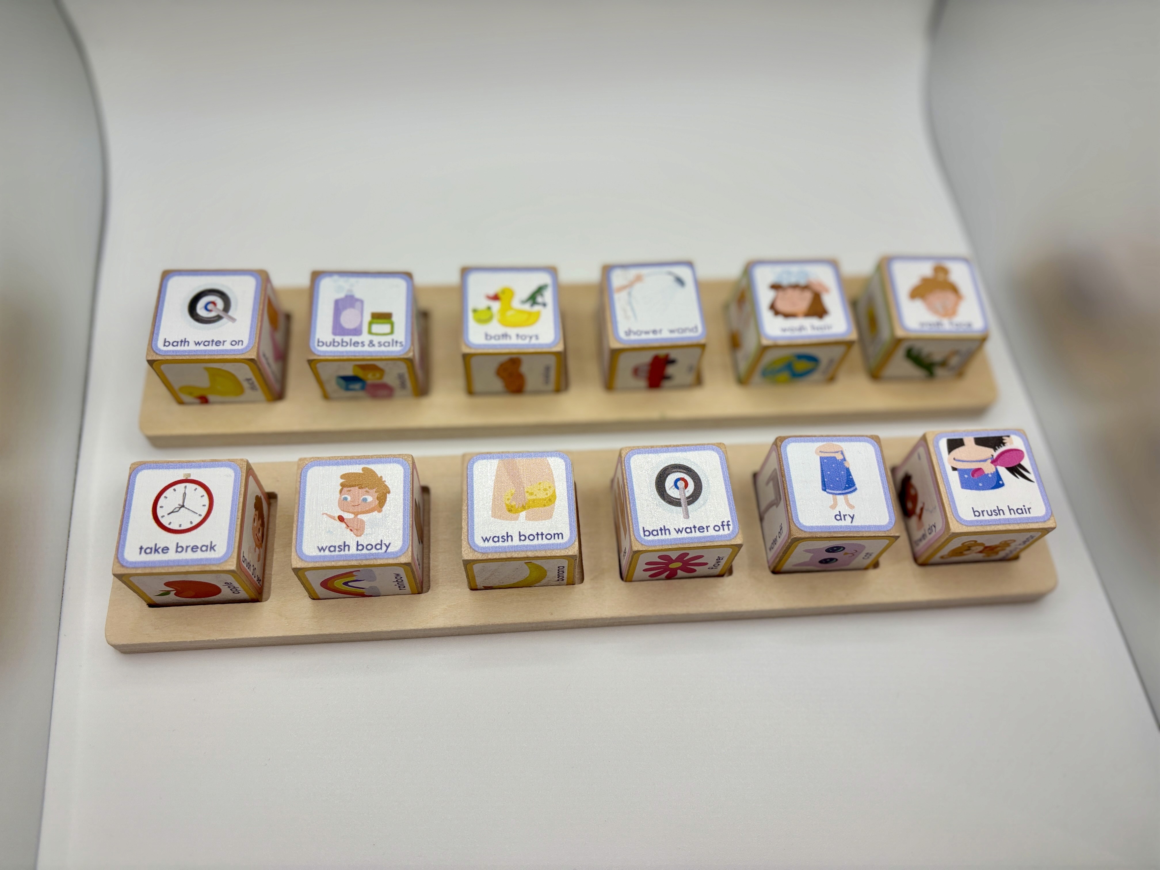 wooden blocks in a tray that show executive functioning steps for taking a bath