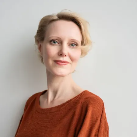 Portrait of a calm woman in a terracotta top representing the Emotional Support & Midlife Identity prompt pack for menopause coaches