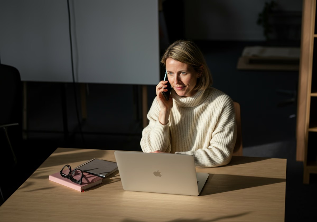 Woman sat on the phone at a laptop