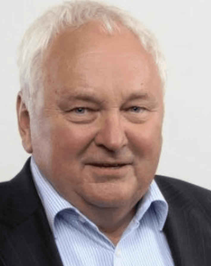 A man holding a cocktail in a dimly lit bar